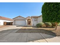 Charming single-story home with a two-car garage and a well-manicured desert landscape at 18203 W Port Royale Ln, Surprise, AZ 85388