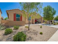 Charming single-story home boasts a well-maintained desert landscape and convenient drive-through garage at 18241 W Foothill Dr, Surprise, AZ 85387