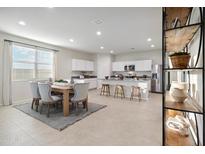 Bright eat-in kitchen with dining table, island with bar seating, and stainless steel appliances at 22650 N Lynn St, Maricopa, AZ 85138