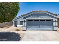 Charming single-story home featuring a well-maintained lawn and attached two-car garage at 310 E Payton St, San Tan Valley, AZ 85140