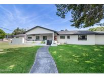 Charming home with a well-manicured lawn, inviting walkway, and covered porch area at 3102 E Mariposa St, Phoenix, AZ 85016