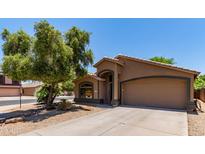 Charming single-story home features a two-car garage, neutral stucco, and low maintenance desert landscaping at 42551 W Anne Ln, Maricopa, AZ 85138