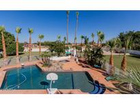 Enjoy this backyard featuring a pool, palm trees, spa, and beautiful landscaping at 5237 N 106Th Ave, Glendale, AZ 85307