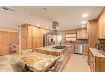 Spacious kitchen features a large island with cooktop, stainless steel appliances, and granite countertops at 6329 E Voltaire Ave, Scottsdale, AZ 85254