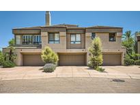 Contemporary townhome featuring three garage doors and well-maintained landscaping at 7400 E Gainey Club Dr # 206, Scottsdale, AZ 85258
