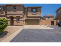 Inviting two-story townhome with a two-car garage and a well-maintained, desert-landscaped front yard at 9534 N 82Nd Ln, Peoria, AZ 85345