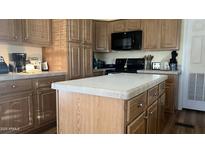 Traditional-style kitchen with wood cabinets, center island, and black appliances at 11596 W Sierra Dawn Blvd # 247, Surprise, AZ 85378