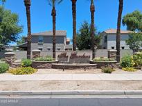 Well-maintained community entrance featuring mature palm trees and colorful landscaping welcoming you to The Gardens at 1465 S Longspur S Ln, Gilbert, AZ 85296
