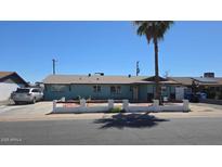 Charming single-story home with a palm tree in the front yard on a sunny day at 4810 N 69Th Dr Dr, Phoenix, AZ 85033