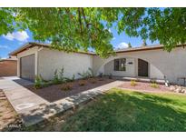 Charming single-story home with manicured lawn, desert landscaping, and inviting arched entryway at 4837 E Pershing Ave, Scottsdale, AZ 85254
