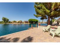 Stunning waterfront backyard featuring a patio and views of the serene lake at 608 E Stonebridge Dr, Gilbert, AZ 85234