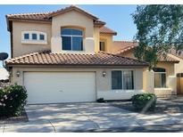 Two story home featuring tile roofing, stucco siding, attached two car garage and manicured front yard at 6923 W Laredo St, Chandler, AZ 85226