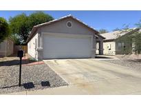 Traditional single-story home featuring a two-car garage and neutral desert landscape at 8308 W Baxter Dr, Phoenix, AZ 85037