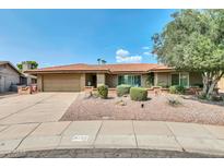 Charming single-story home featuring a well-maintained front yard, mature tree, and an attached two-car garage at 8532 E San Bruno Dr, Scottsdale, AZ 85258