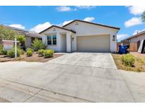 Charming single-Gathering home with desert landscaping and a two-car garage against a blue sky at 12375 W Whyman Ave, Avondale, AZ 85323