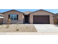 Charming single-story home with a two-car garage, stone accents, and low maintenance landscaping at 37212 W Parador Ln, Maricopa, AZ 85138