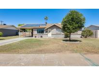 Charming single-story home featuring solar panels, a covered parking area, and a well-maintained front yard at 856 N Evergreen St, Chandler, AZ 85225