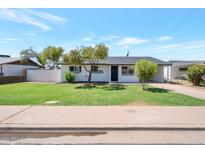 Charming single-story home featuring a well-manicured lawn and mature trees in a desirable neighborhood at 1051 E Millett Ave, Mesa, AZ 85204