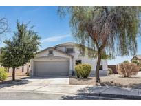 Charming single-story home with a well-manicured front yard and a two-car garage on a sunny day at 1225 N 159Th Ln, Goodyear, AZ 85338