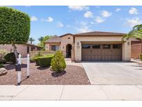 Charming home featuring a two-car garage and a meticulously manicured front yard with attractive desert landscaping at 12945 W Yellow Bird Ln, Peoria, AZ 85383