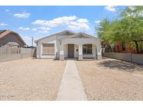 Charming single-story home featuring white stucco, front porch, and low-maintenance desert landscaping at 1510 W Fillmore St, Phoenix, AZ 85007