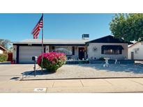 Charming home featuring a well-manicured yard, American flag, and single-car garage at 1710 W 13Th Ave, Apache Junction, AZ 85120