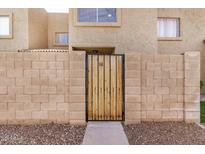 A charming brick-walled entrance with a wooden gate and a glimpse of the building's facade at 222 W Brown Rd # 14, Mesa, AZ 85201