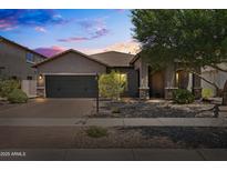 Charming single-story home featuring a desert landscape, a two-car garage, and a covered entryway at 3022 E Santa Fe Ln, Gilbert, AZ 85297