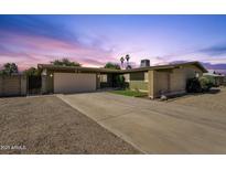 Charming single-level home with a spacious driveway and desert landscaping at twilight at 3537 W Shangri La Rd, Phoenix, AZ 85029