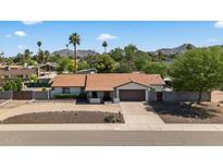 Charming single-story home with a well-maintained front yard, mountain views, and an attached two-car garage at 5101 E Paradise Dr, Scottsdale, AZ 85254