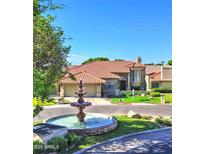 Beautiful single-Gathering home featuring a meticulously landscaped front yard and charming fountain in the circular driveway at 5431 E Piping Rock Rd, Scottsdale, AZ 85254