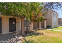 Exterior view of tan townhouse with security door and manicured lawn at 7126 N 19Th Ave # 152, Phoenix, AZ 85021