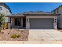 Charming single-story home with gray trim, a gray garage door, and desert landscaping at 17032 W Cavedale Dr, Surprise, AZ 85387