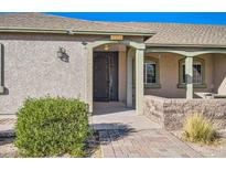 Inviting front entrance with decorative iron door and well-maintained landscaping at 2602 S 226Th Dr, Buckeye, AZ 85326