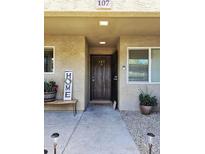Charming front entrance with a rustic wood door and lovely landscaping, inviting guests into a cozy home at 4050 E Cactus Rd # 107, Phoenix, AZ 85032
