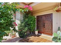 Charming front entrance featuring wood double doors and vibrant bougainvillea accents at 4525 N 66Th St # 1, Scottsdale, AZ 85251