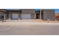 Striking new build featuring a three-car garage with modern gray tones and contemporary design at 5145 N Ascent Dr, Scottsdale, AZ 85251