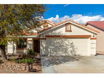 Charming single-story home featuring a two-car garage, desert landscaping and a welcoming front porch at 13864 W Ironwood St, Surprise, AZ 85374