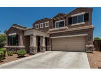 Inviting two-story home showcasing a spacious two-car garage and manicured front yard landscape under a clear, blue sky at 1723 N Hillcrest --, Mesa, AZ 85201