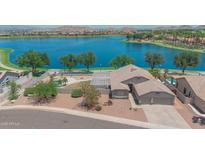 Beautiful lakefront home featuring a backyard pool and a covered patio, perfect for outdoor entertaining at 18088 W San Alejandro Dr, Goodyear, AZ 85338