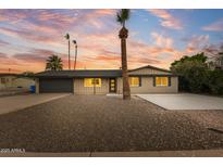 Charming home boasts desert landscaping, complemented by palm trees and a newly sealed driveway at 1911 E Lawrence Rd, Phoenix, AZ 85016