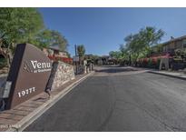View of the Venu at Grayhawk community entrance with stone accents, beautiful landscaping, and clear signage at 19777 N 76Th St # 2142, Scottsdale, AZ 85255