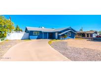 Charming blue single-story home featuring a well-manicured front yard and a concrete driveway at 3115 N 55Th Ave, Phoenix, AZ 85031