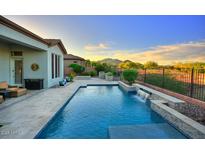 Resort-style pool with a tranquil waterfall feature and mountain views, perfect for relaxation and outdoor enjoyment at 40613 N Candlewyck Ln, Anthem, AZ 85086