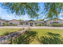 Stunning single-story home with lush lawn, manicured landscaping, and charming front entry at 8213 E Sharon Dr, Scottsdale, AZ 85260