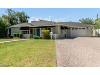 Charming single-story home featuring a brick driveway, a well-manicured lawn, and black awnings for a timeless look at 152 W 2Nd St, Mesa, AZ 85201