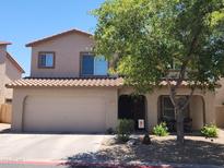 Charming two-story home featuring a lush shade tree and a convenient two-car garage at 2317 E Mohave Ln, Apache Junction, AZ 85119