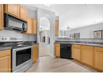 Bright kitchen features stainless steel appliances, wood cabinets, and an open view to the living area at 2565 S Signal Butte Rd # 30, Mesa, AZ 85209