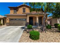 Charming two-story home featuring a well-manicured lawn, covered porch, and attached two-car garage at 27189 N 75Th Dr, Peoria, AZ 85383