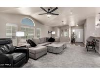 Spacious living room with vaulted ceilings, fan, large windows, and comfortable seating at 3301 S Goldfield Rd # 1048, Apache Junction, AZ 85119